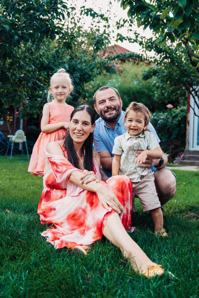 Ședință foto familie în grădină, lumină naturală caldă, părinți și doi copii