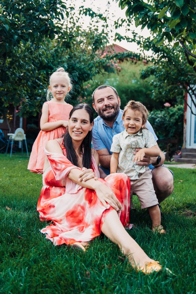 Ședință foto familie în grădină, lumină naturală caldă, părinți și doi copii