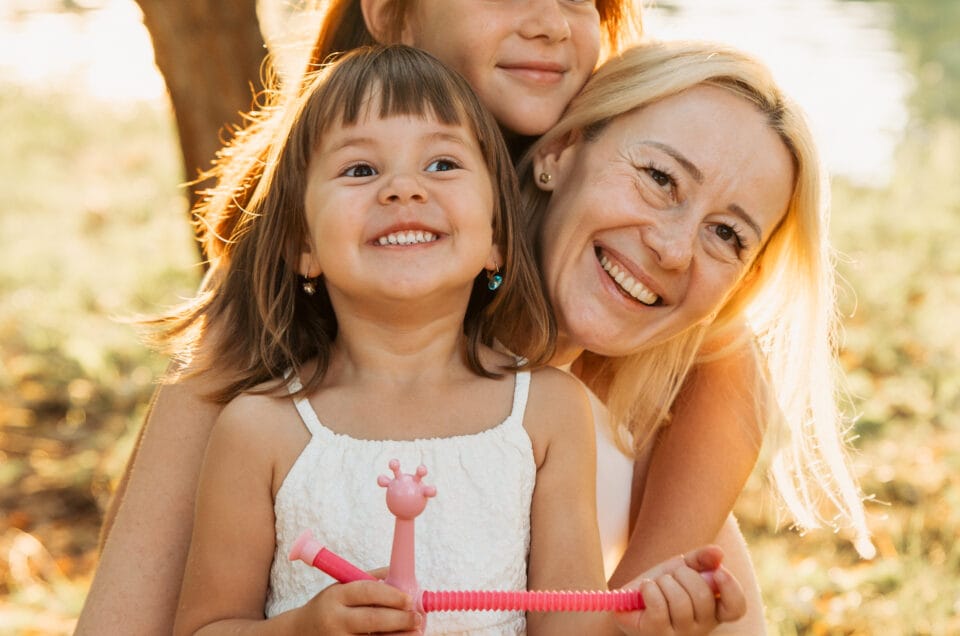 Ședință foto familie cu două fetițe și mamă în parc la lumină caldă de aur