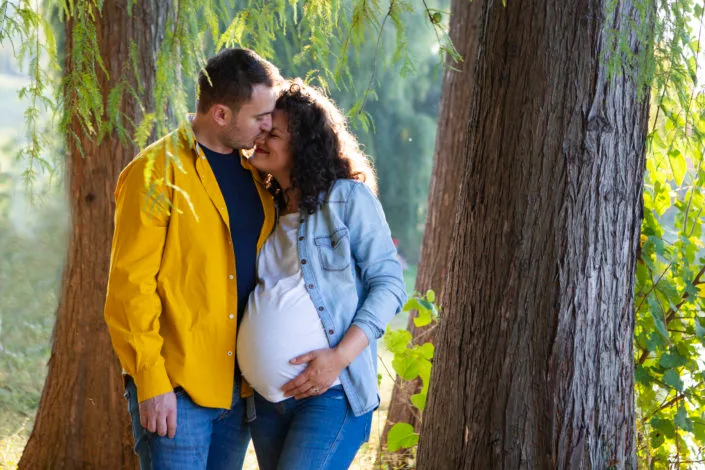 Ședință foto maternitate cuplu în parc, lumină naturală caldă și intimitate autentică