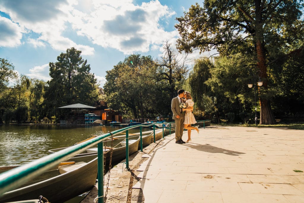 Cuplu de miri sărutându-se pe ponton lângă lac, fotografie de nuntă București