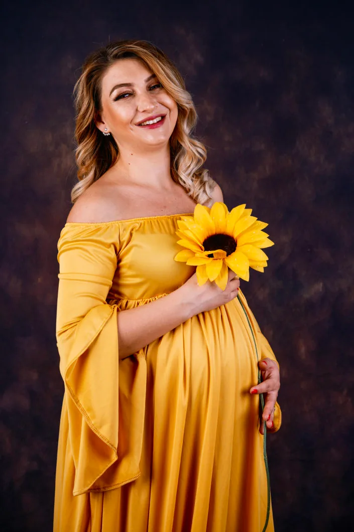 Femeie însărcinată cu floarea-soarelui, ședință foto maternitate elegantă în studio București