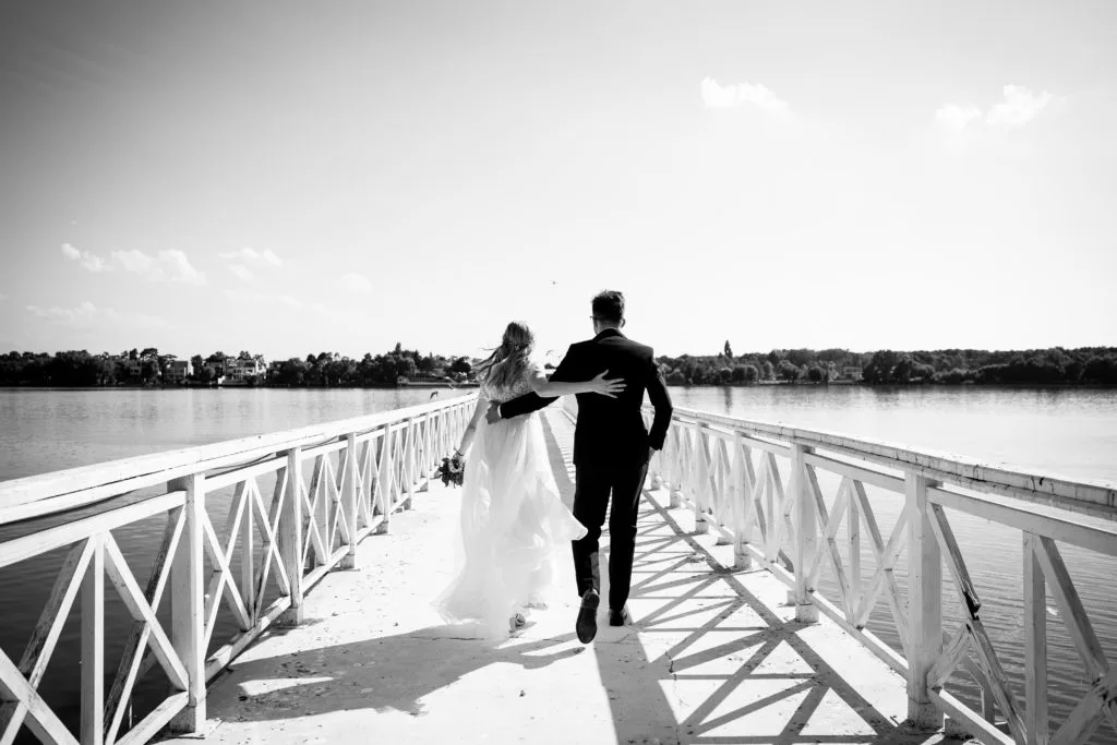 Miri alergând pe ponton deasupra lacului, fotografie de nuntă alb-negru București
