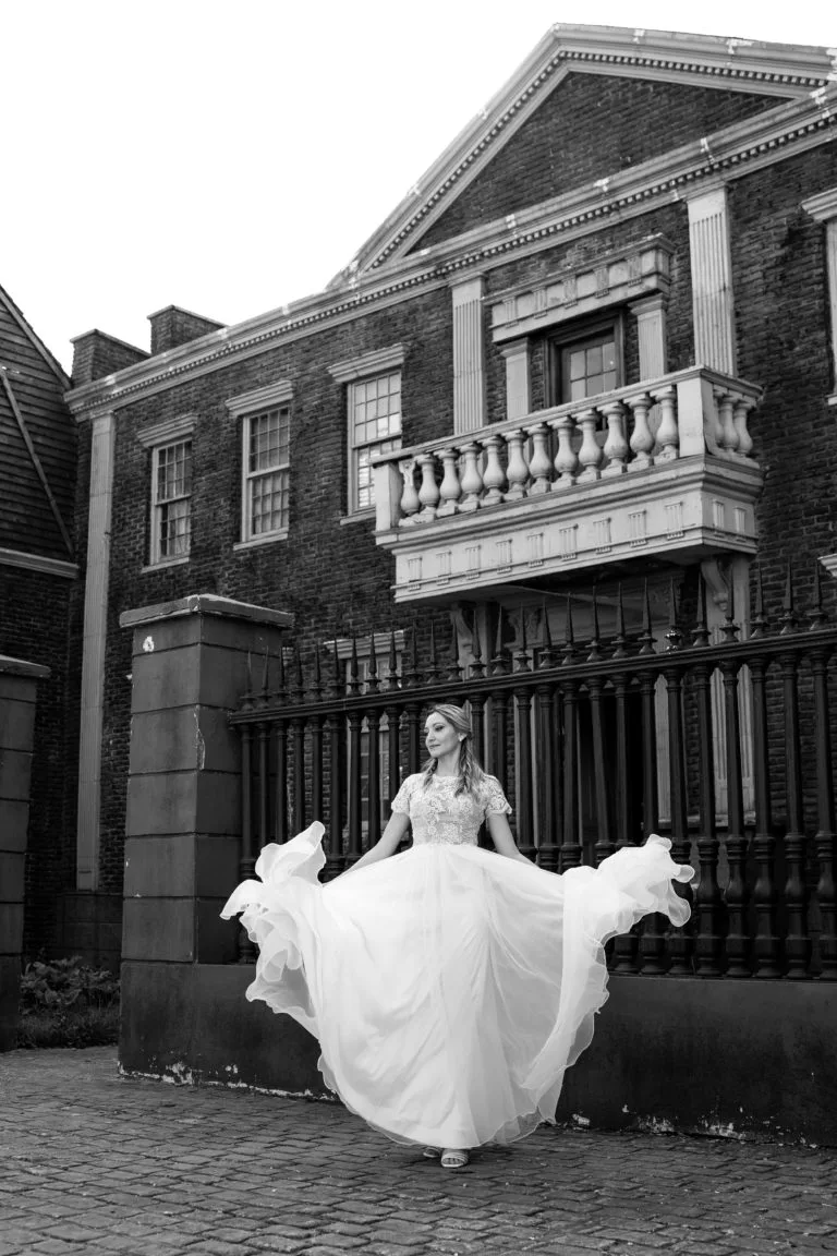 Mireasă rotindu-se în rochie albă fluturândă, fotografie elegantă de nuntă în exterior