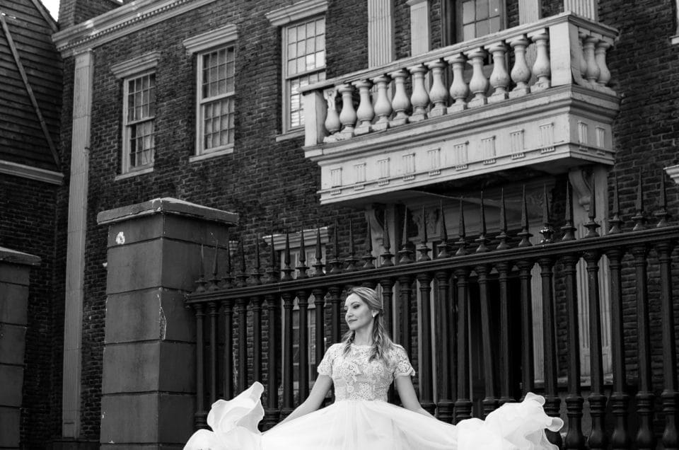 Mireasă rotindu-se în rochie albă fluturândă, fotografie elegantă de nuntă în exterior