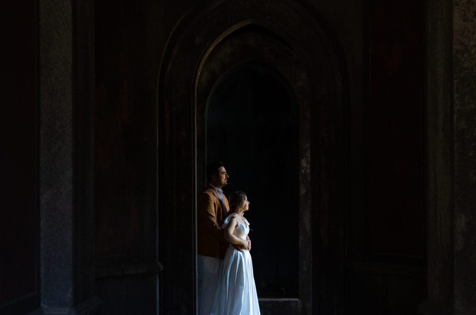 Cuplu de miri în arcadele unui castel, fotografie artistică dramatică București