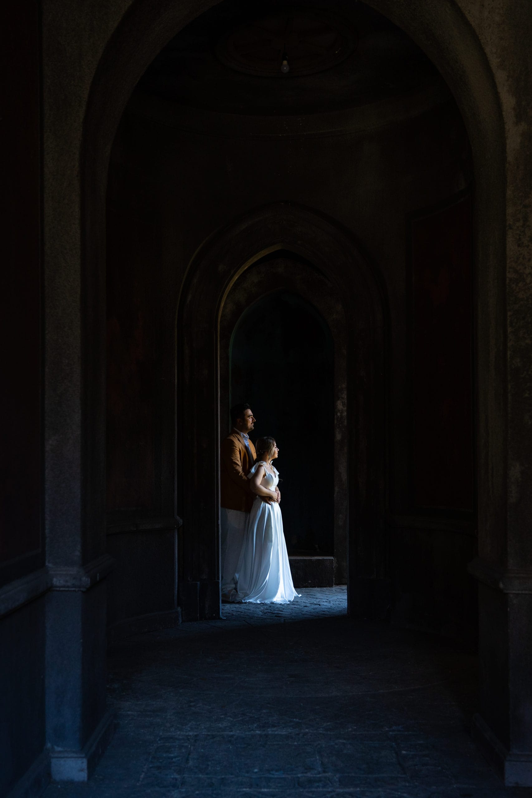 Cuplu de miri în arcadele unui castel, fotografie artistică dramatică București