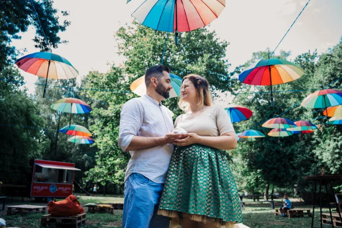 Ședință foto cuplu în parc cu umbrele colorate, atmosferă jucăușă și luminoasă