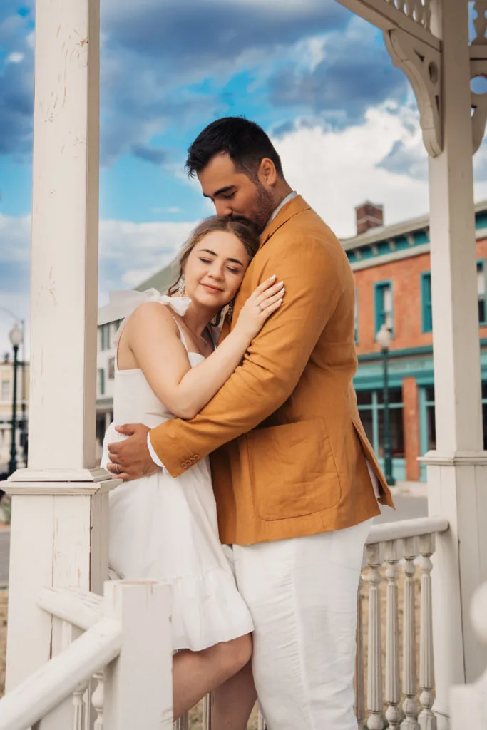 Cuplu în îmbrățișare romantică pe verandă, ședință foto logodnă în aer liber