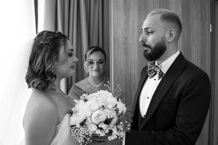 Mire și mireasă față în față cu buchet, fotografie emoționantă de nuntă alb-negru