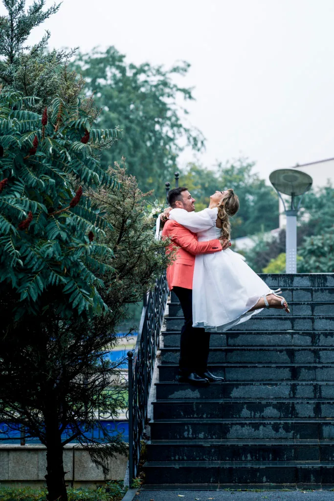 Mire ridicând mireasa pe scări în parc, fotografie romantică de nuntă București