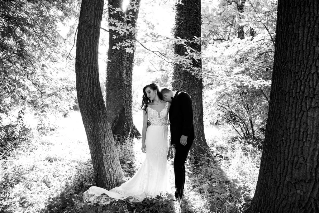 Miri în pădure, mire sărutând mireasa pe umăr, fotografie artistică de nuntă București