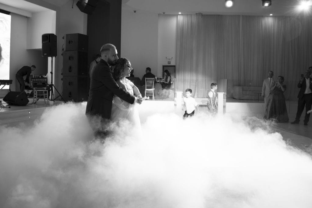 Miri dansând pe ceață artificială la recepție, fotografie de nuntă în sală elegantă