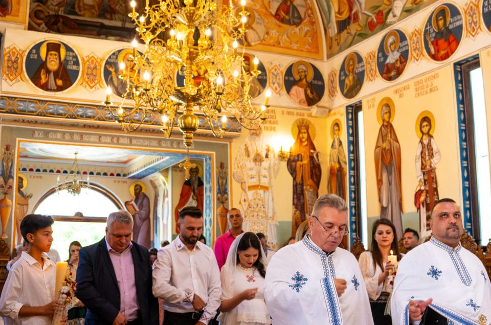 Preot și copil la botez în biserică ortodoxă cu fresce, fotografie emoționantă București