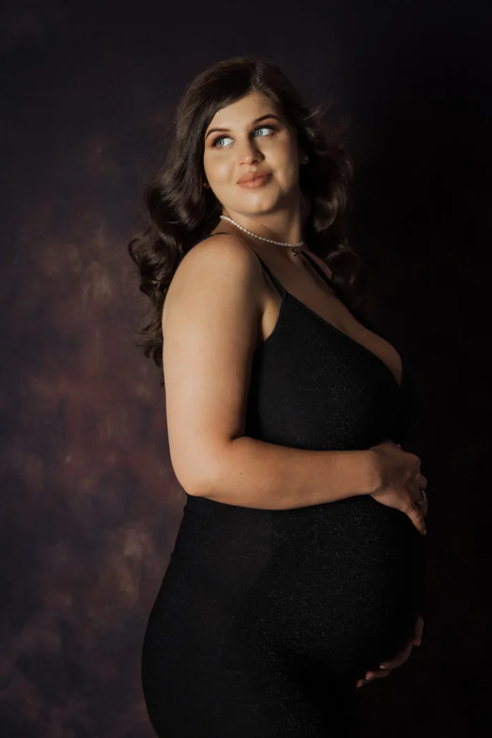 Femeie însărcinată în rochie neagră elegantă, ședință foto maternitate studio București
