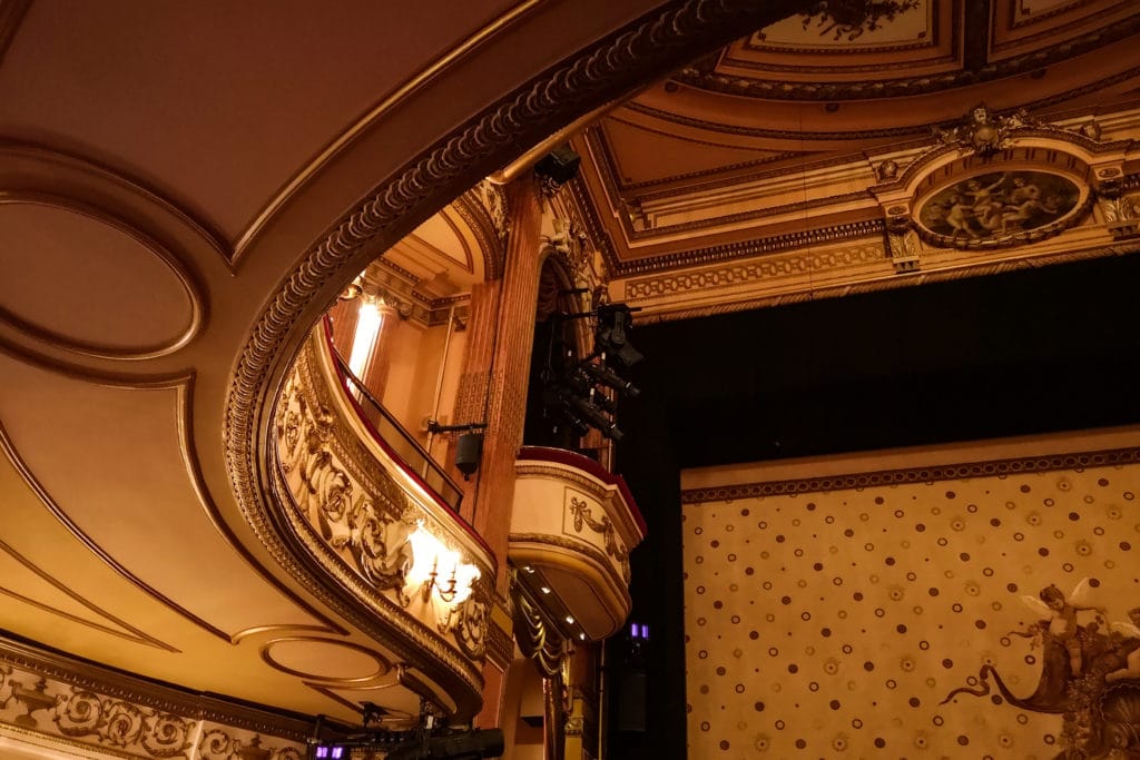 Interior elegant de teatru cu balcoane aurite și lumină caldă, atmosferă rafinată București