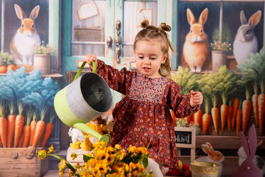 Fetiță jucăușă cu stropitoare la ședință foto de Paște, studio București