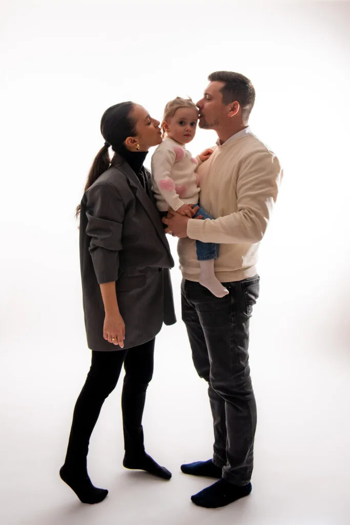 Familie fericită cu bebeluș în studio, fotografie profesională de botez București