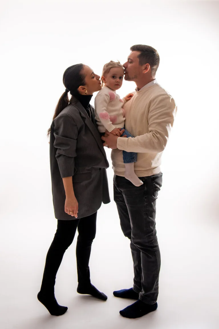 Familie fericită cu bebeluș în studio, fotografie profesională de botez București