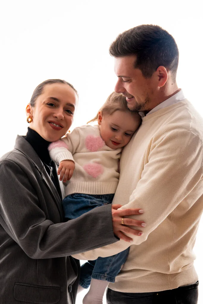 Familie fericită cu fetiță în brațe, ședință foto studio București luminoasă