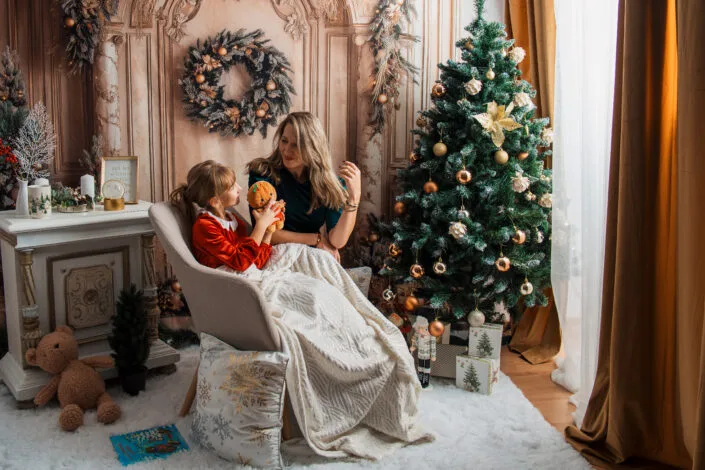 Ședință foto familie de Crăciun, mamă și fetiță lângă brad decorat