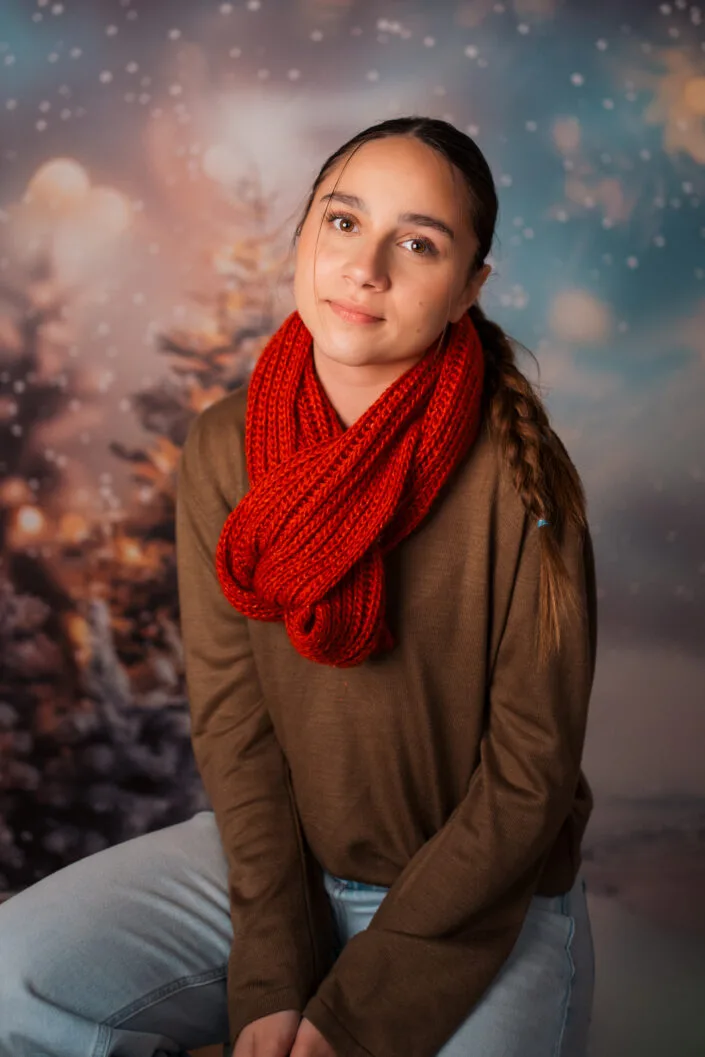 Ședință foto portret tânără cu fular roșu tricotat pe fundal de iarnă