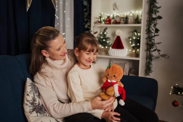 Ședință foto familie de Crăciun, mamă și fetiță cu jucărie gingerbread, atmosferă caldă
