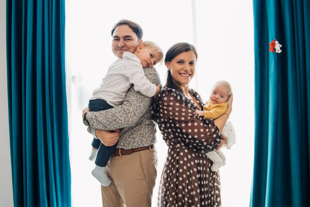 Familie fericită cu doi copii în brațe, ședință foto profesională București