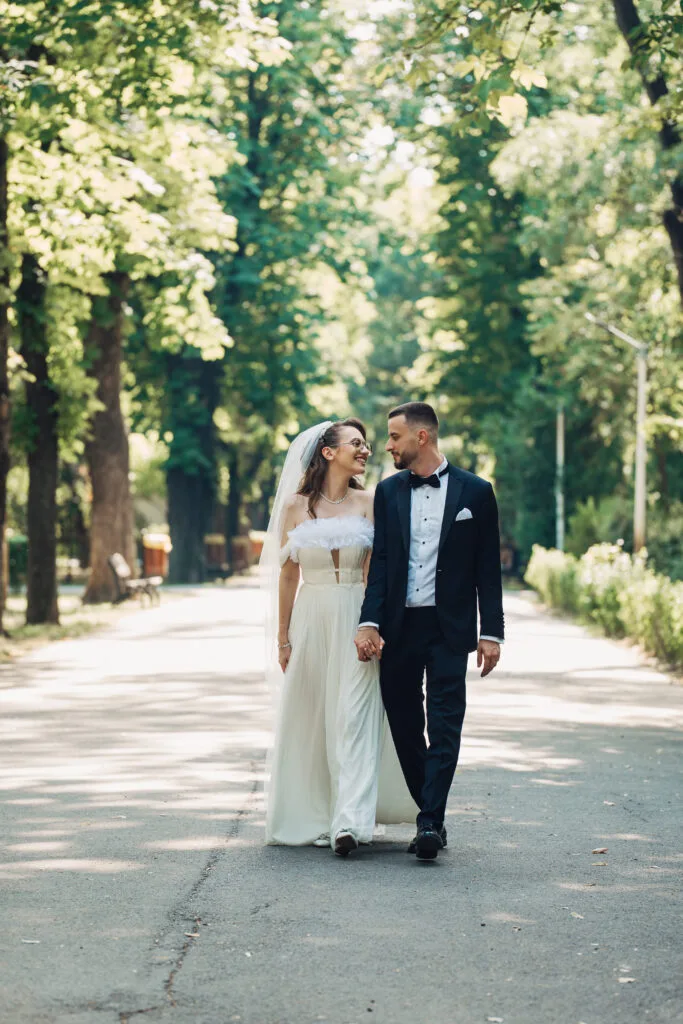 Miri ținându-se de mână în parc, fotografie elegantă de nuntă București